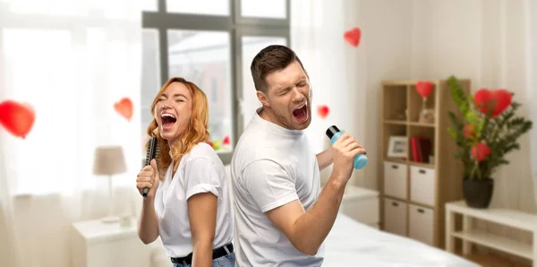 Couple chantant à la brosse à cheveux et lotion à la maison — Photo