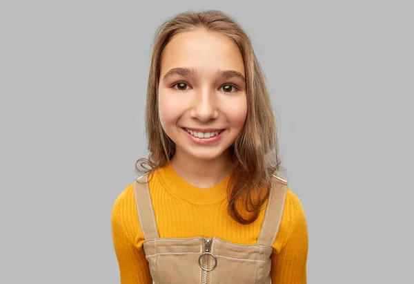 Lächelndes Teenager-Mädchen vor grauem Hintergrund — Stockfoto