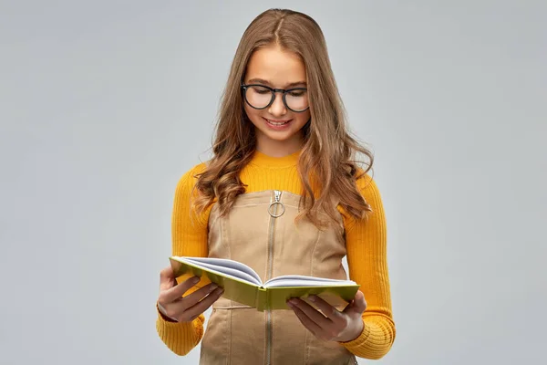 Adolescente estudiante chica en gafas lectura libro — Foto de Stock