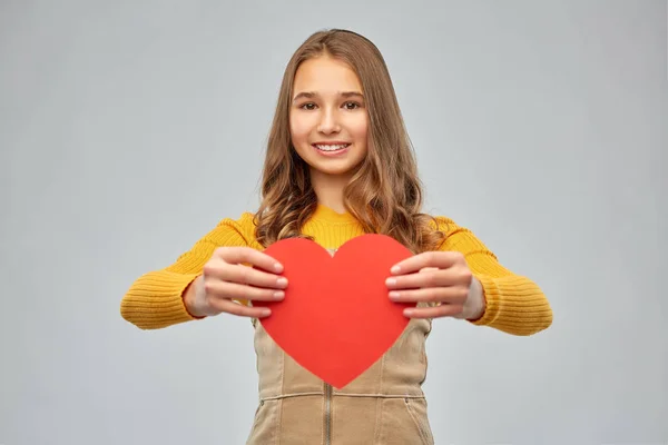 Kırmızı kalp ile gülümseyen genç kız — Stok fotoğraf