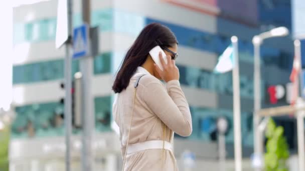 Lachende Aziatische vrouw die op een smartphone belt in de stad — Stockvideo