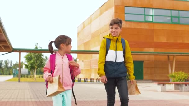 Barn med ryggsäckar går i skolan — Stockvideo