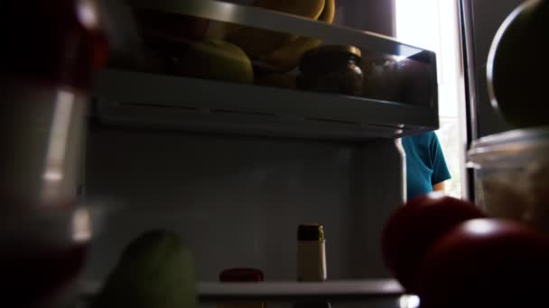 Mulher tomando maçã da geladeira em casa cozinha — Vídeo de Stock