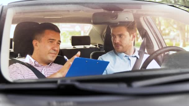 Fahrschullehrer im Gespräch mit Fahrer — Stockvideo
