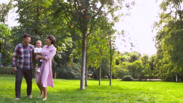 Família feliz andando no parque de verão — Vídeo de Stock