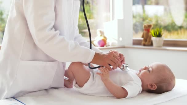 Médico con estetoscopio escuchando al bebé paciente — Vídeo de stock