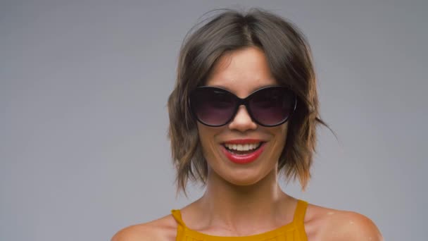 Счастливая смеющаяся молодая женщина в черных солнцезащитных очках — стоковое видео