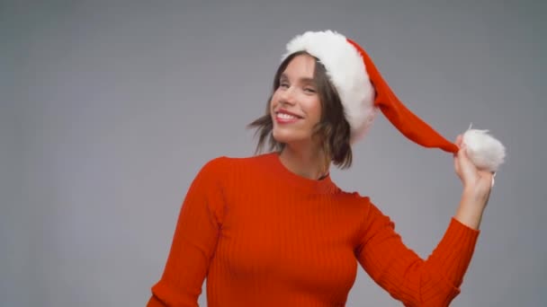 サンタヘルパーの帽子の女性はクリスマスを楽しんでいます — ストック動画
