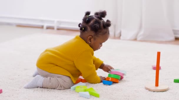 Αφρικανική κοριτσάκι παίζει με μπλοκ παιχνιδιών στο σπίτι — Αρχείο Βίντεο