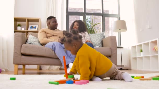 Мати, батько і дитина грають в іграшкові блоки вдома — стокове відео