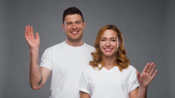 Ζευγάρι σε λευκό t-shirts κουνώντας τα χέρια — Αρχείο Βίντεο