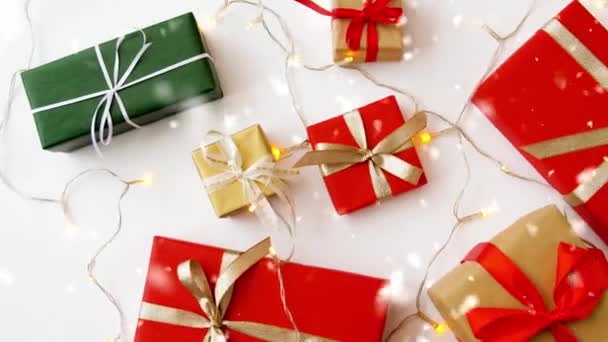 크리스마스 선물 과 갈런드 조명에 눈이 내리고 있다 — 비디오