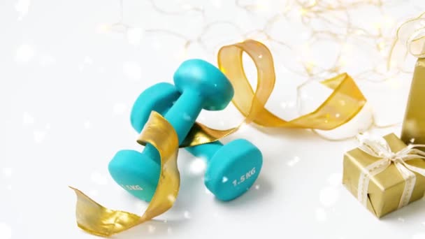 Snowing over christmas gift boxes and dumbbells — Stock Video