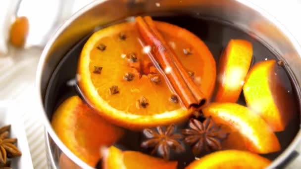 Gewürze und heißer Glühwein mit Orangenscheiben — Stockvideo