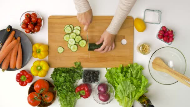 Mujer joven cortando pepino en casa — Vídeos de Stock