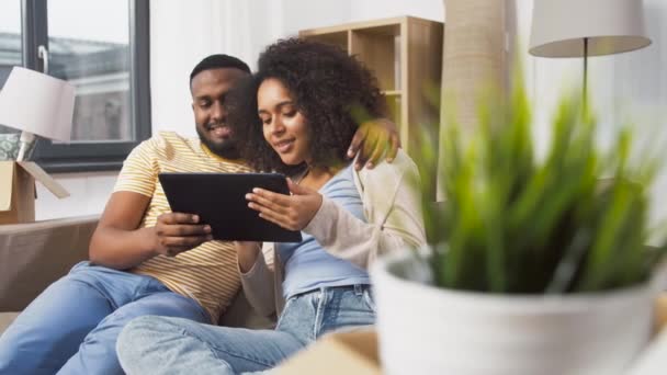 Gelukkig paar met tablet pc computer in nieuw huis — Stockvideo