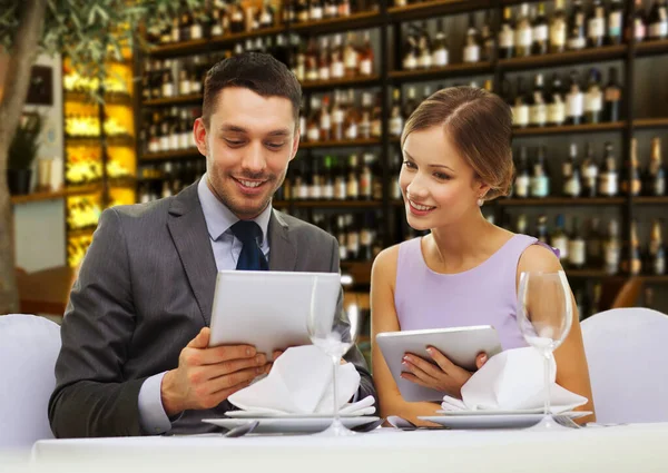 Пара с меню на планшете ПК в ресторане — стоковое фото