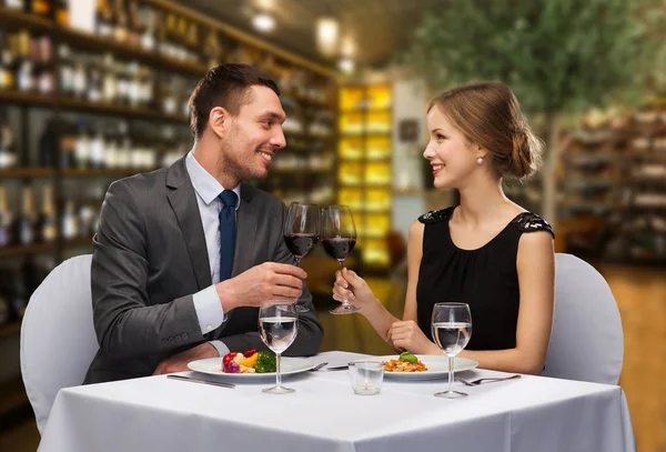 Usmívající se pár cinkání sklenice na víno v restauraci — Stock fotografie