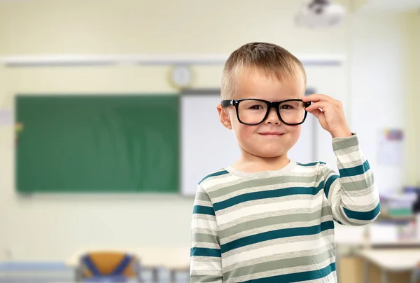 Porträtt av leende pojke i glasögon i skolan — Stockfoto