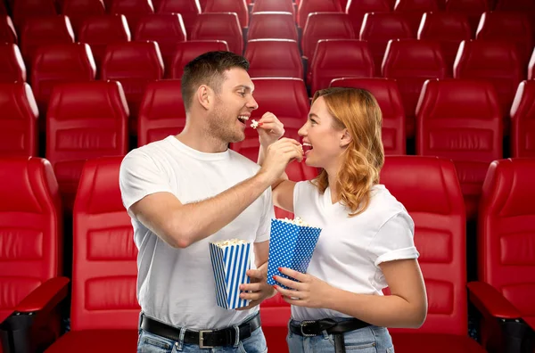 Happy couple eating popcorn at movie theatre — Stock Photo, Image