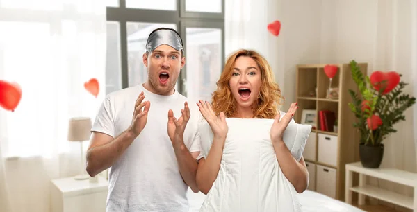 Scared couple with eye sleeping mask and pillow — Stock Photo, Image