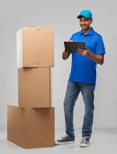 Indian delivery man with tablet pc and boxes — Stock Photo, Image