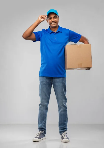 Щасливий індійський чоловік доставки з посилкою в синьому — стокове фото
