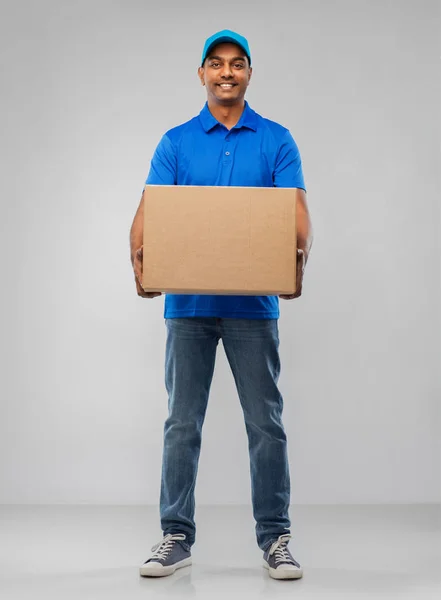 Glücklicher indischer Zusteller mit Paketkasten in blau — Stockfoto