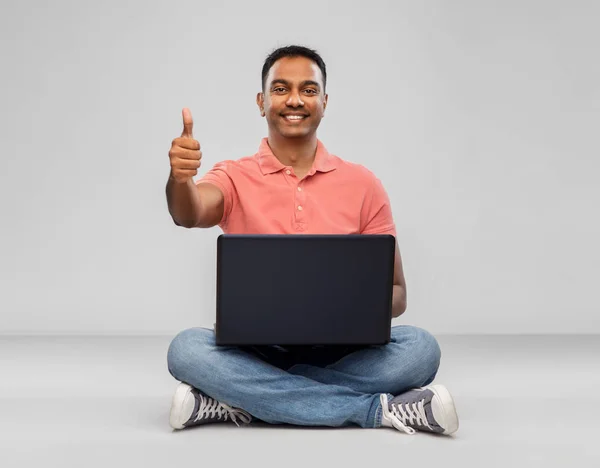 Glad indian man med bärbar dator visar tummen upp — Stockfoto