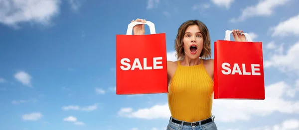 Verraste jonge vrouw met boodschappentassen te koop — Stockfoto