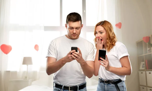 Ευτυχισμένο ζευγάρι με smartphones την ημέρα του Αγίου Βαλεντίνου — Φωτογραφία Αρχείου