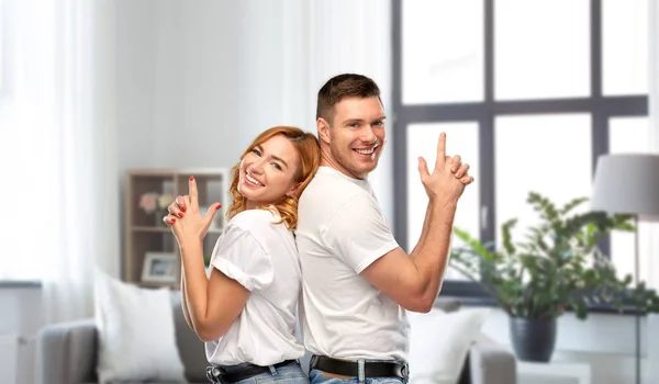 Casal em camisetas brancas camisas fazendo gesto arma — Fotografia de Stock