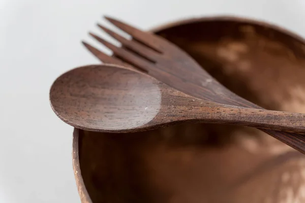 Close up of coconut bowl, wooden spoon and fork — Stock Photo, Image