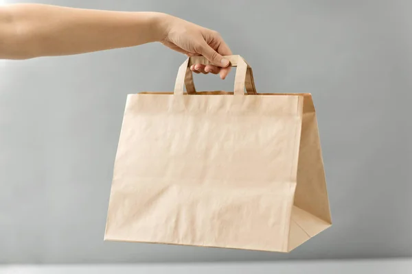 Tangan memegang tangan mengambil makanan dalam kantong kertas dengan makan siang — Stok Foto