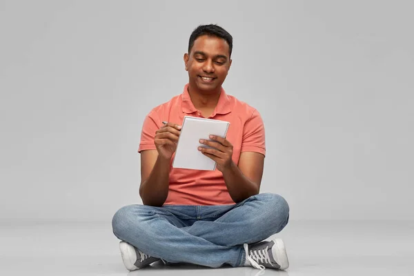 Indian man i polotröja skriva till anteckningsbok — Stockfoto