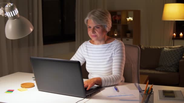 Evde kahve içen dizüstü bilgisayarı olan yaşlı bir kadın. — Stok video