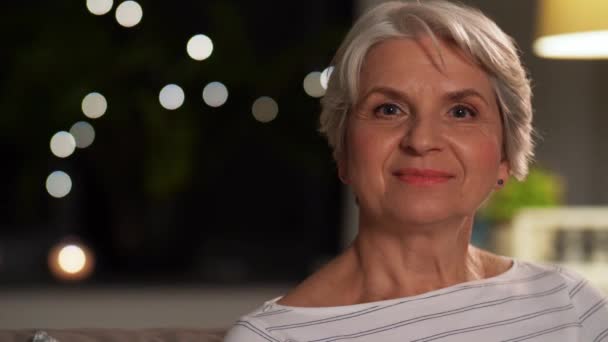Портрет счастливой пожилой женщины дома вечером — стоковое видео