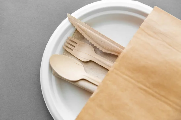 Деревянная ложка, вилка и нож на бумажной тарелке — стоковое фото