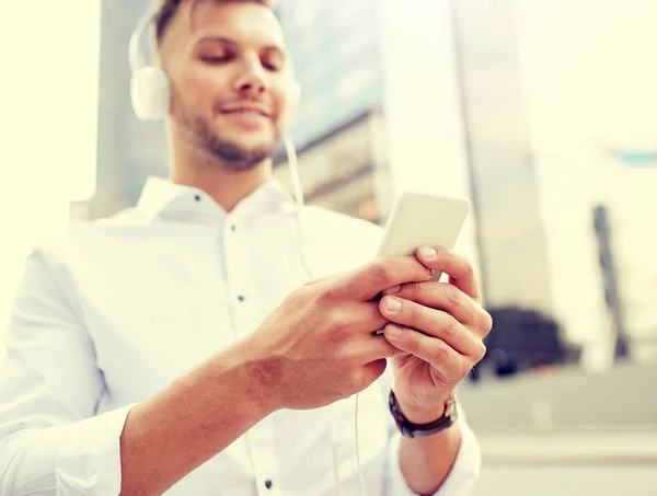 Man with smartphone and headphones listening music — Stock Photo, Image