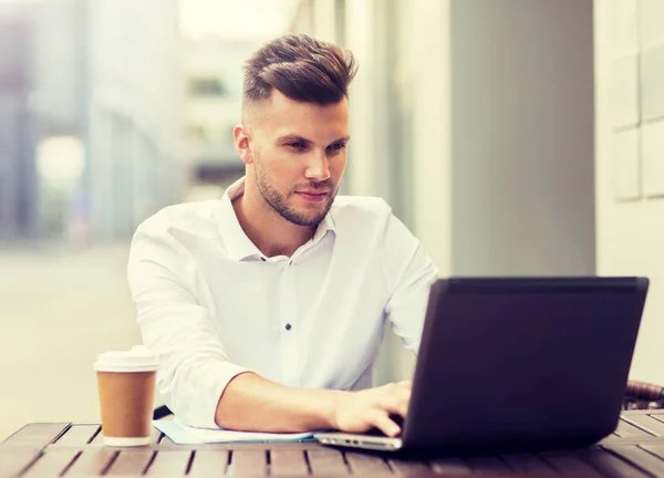 Uomo con computer portatile e caffè al caffè della città — Foto Stock