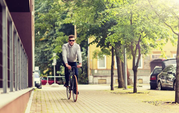 Jeune homme à vélo sur la rue de la ville — Photo