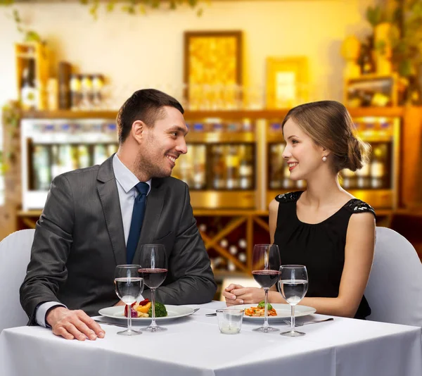 Pareja sonriente con comida y vino en el restaurante — Foto de Stock