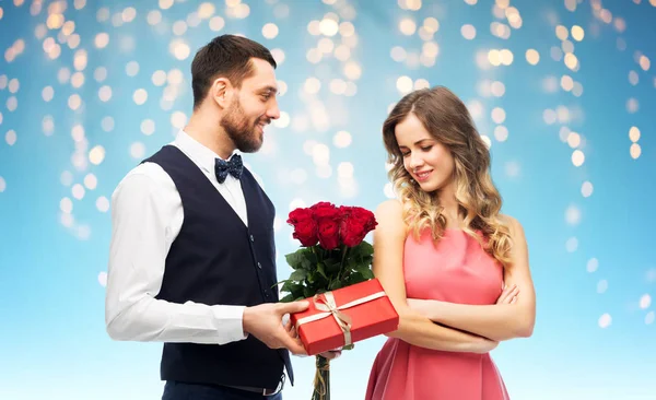 Uomo felice donando fiori donna e presente — Foto Stock