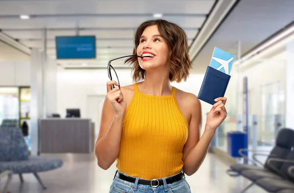 Havaalanında uçak bileti olan mutlu genç bir kadın. — Stok fotoğraf