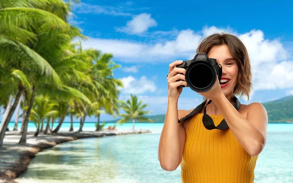 Fotógrafo mulher feliz com câmera na praia — Fotografia de Stock