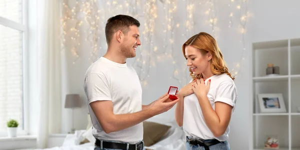 man giving woman engagement ring on valentines day