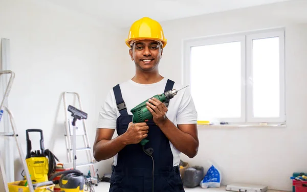 Счастливый индийский строитель в шлеме с электрической дрелью — стоковое фото