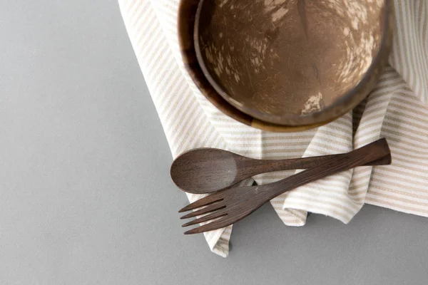 Close up of coconut bowl, wooden spoon and fork — Stock Photo, Image