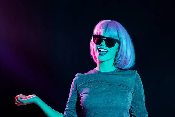 Mujer feliz en peluca rosa y gafas de sol bailando — Foto de Stock