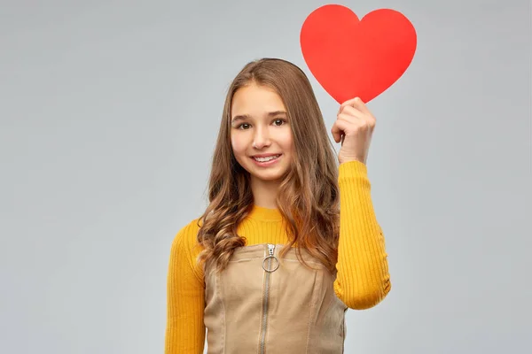 Kırmızı kalp ile gülümseyen genç kız — Stok fotoğraf